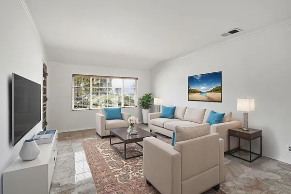 a living room with furniture a flat screen tv and a window