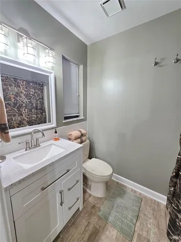 a bathroom with a granite countertop sink mirror vanity and toilet