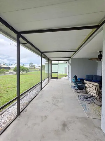 a living room with furniture and floor to ceiling windows
