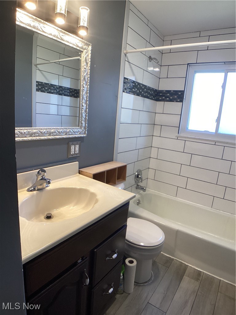 9083 Priem Road Strongsville, OH 44149 - Photo 21 of 28 Bathroom featuring toilet, vanity, wood finished floors, and shower combination