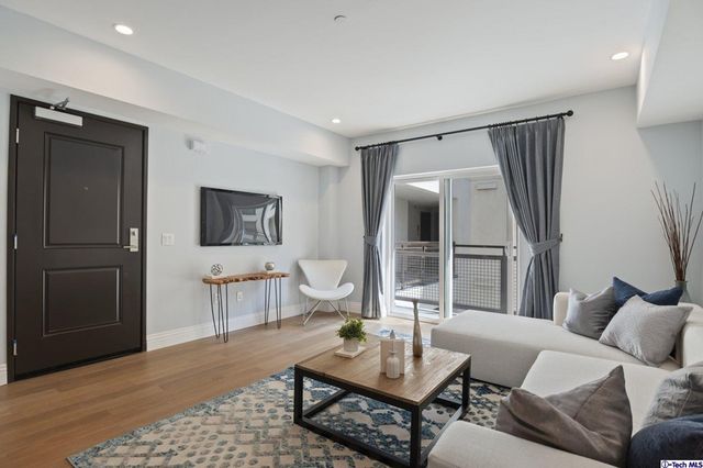 a living room with furniture a rug and a potted plant