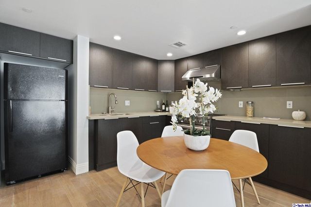 a kitchen with stainless steel appliances a dining table chairs and stove top oven