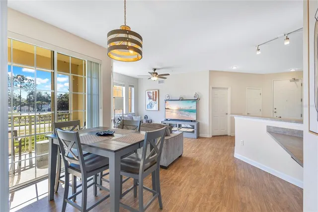 a kitchen with stainless steel appliances granite countertop a stove top oven a refrigerator and a dining table with wooden floor