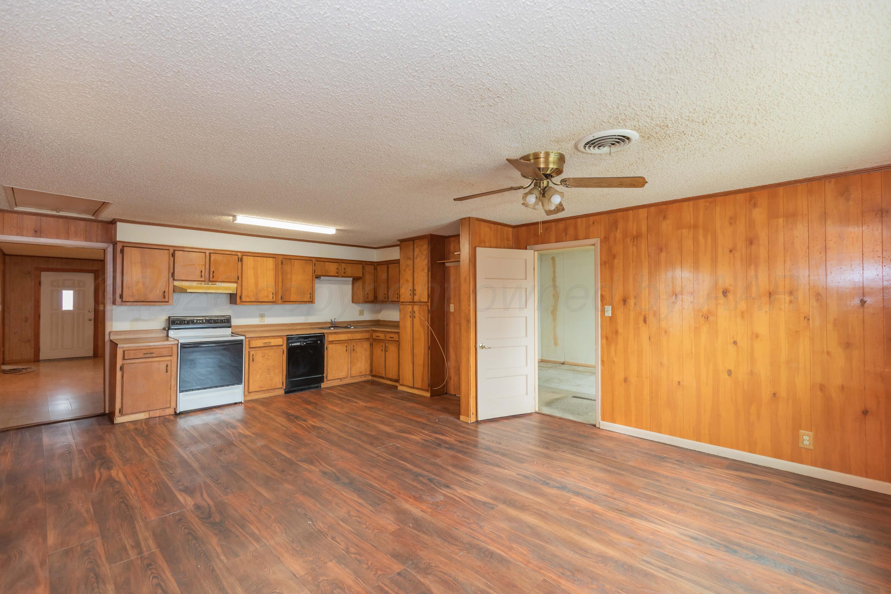 200 South Wall Street Shamrock, TX 79079 - Photo 11 of 40 a view of a kitchen with a stove and wooden floor