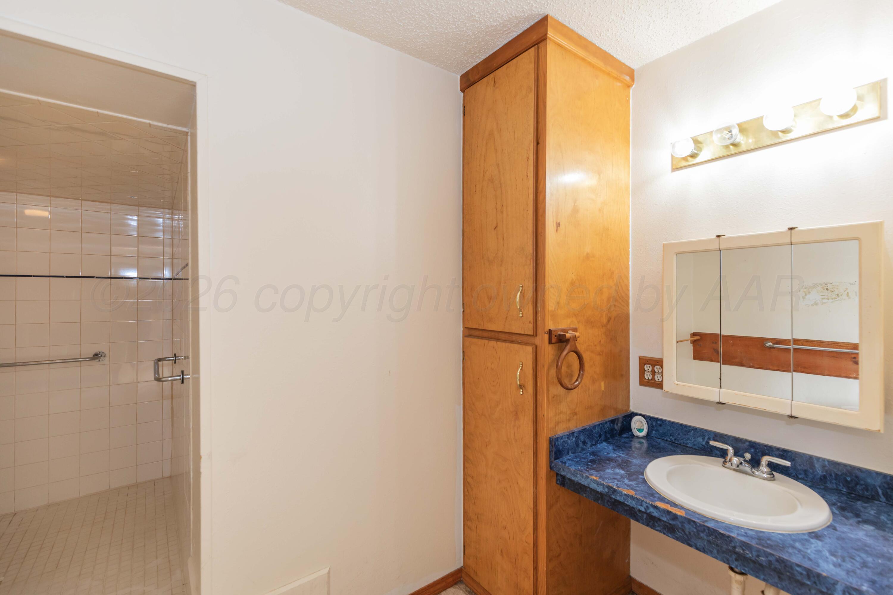 200 South Wall Street Shamrock, TX 79079 - Photo 17 of 40 a bathroom with a sink and a mirror