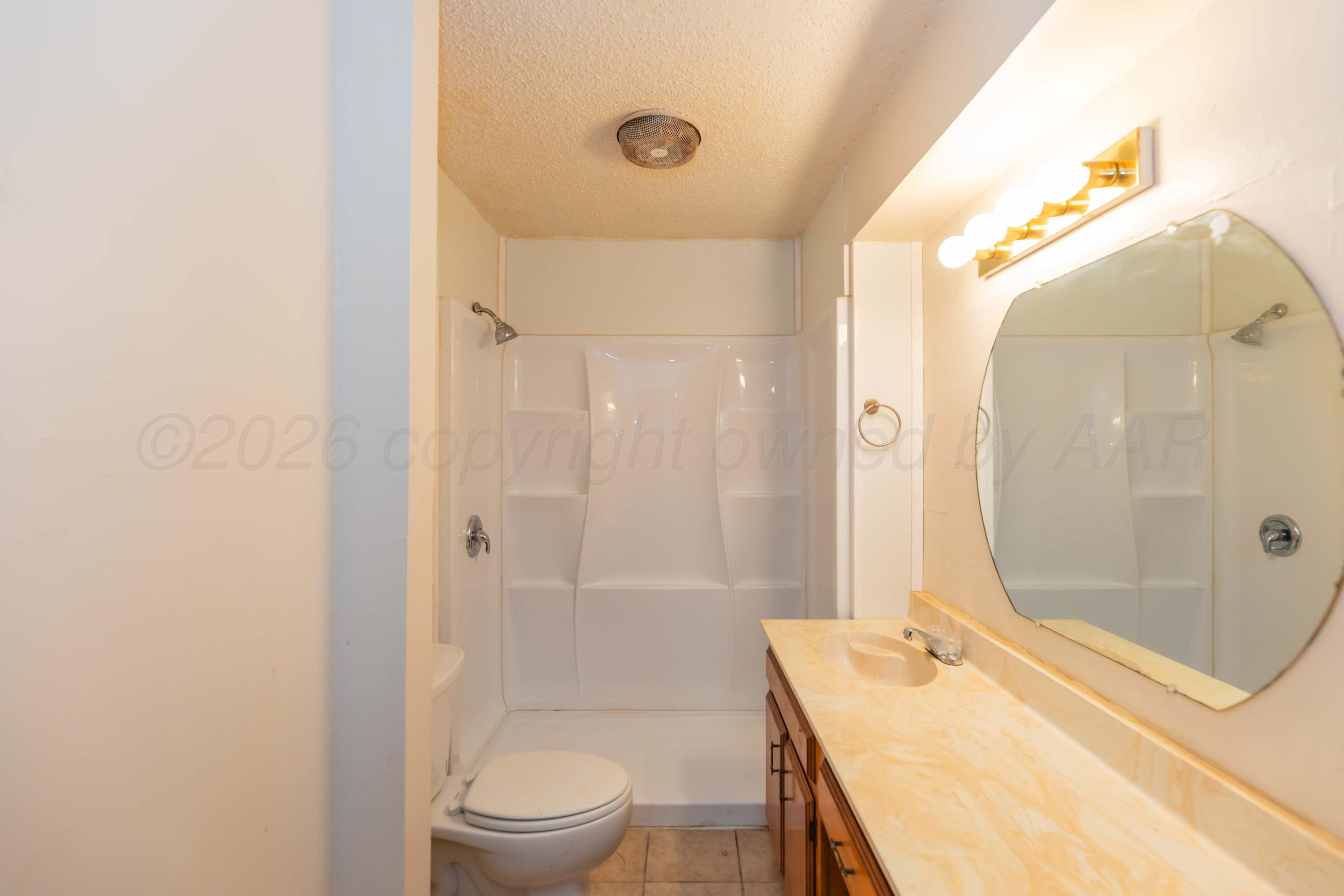200 South Wall Street Shamrock, TX 79079 - Photo 24 of 40 a bathroom with a granite countertop sink a toilet and shower