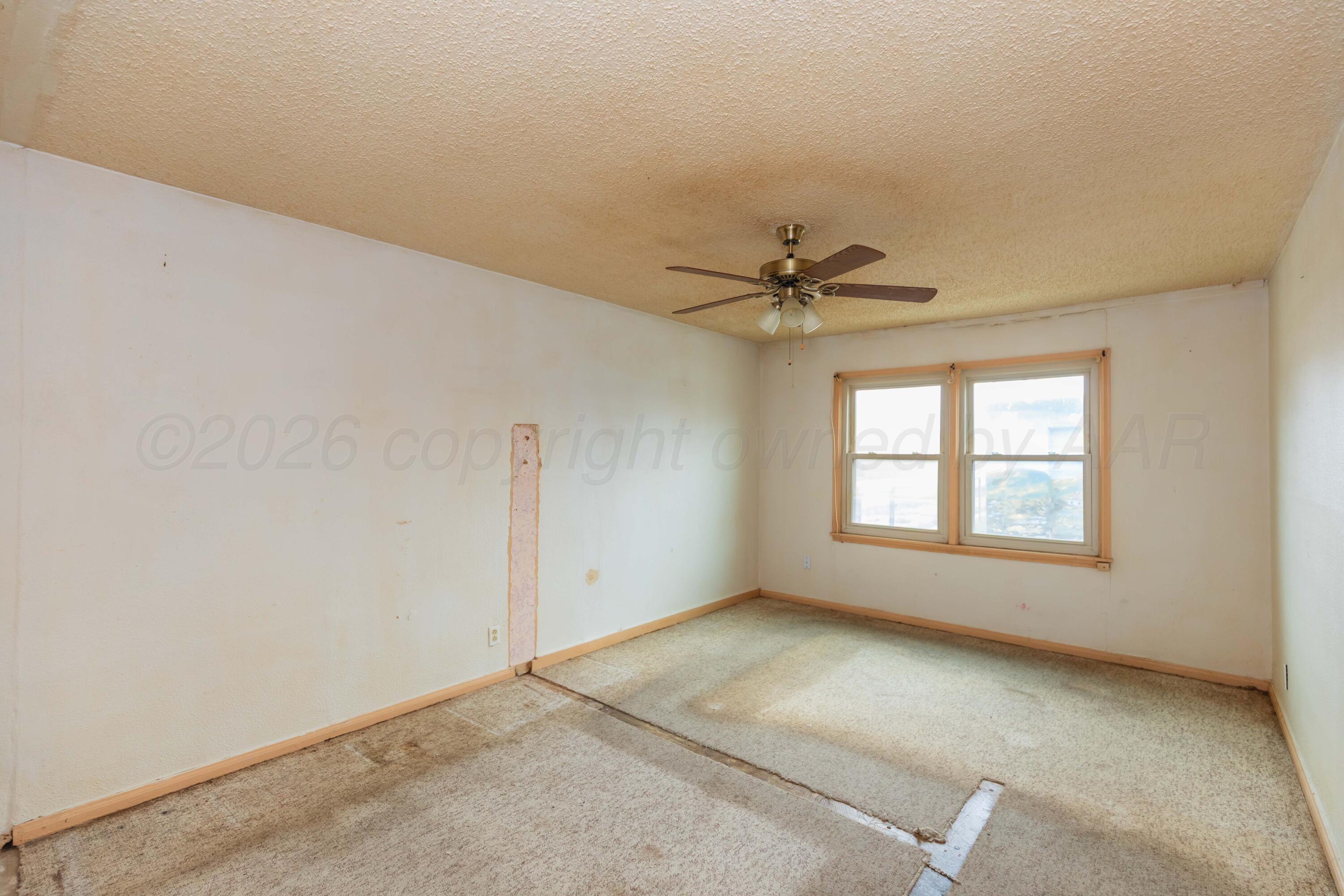200 South Wall Street Shamrock, TX 79079 - Photo 32 of 40 an empty room with a ceiling fan and window