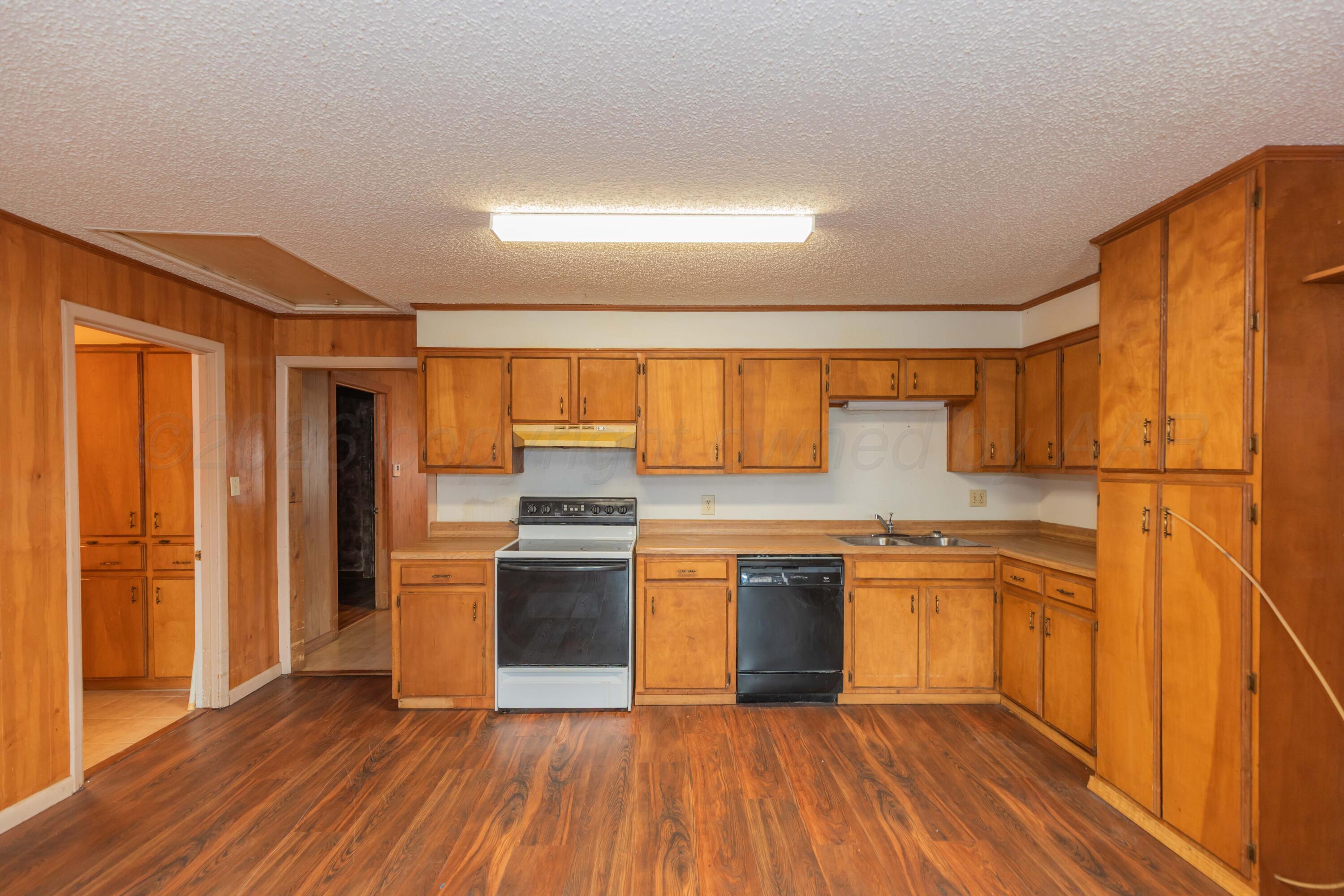 200 South Wall Street Shamrock, TX 79079 - Photo 7 of 40 a kitchen with stainless steel appliances granite countertop a refrigerator a stove and a wooden floors