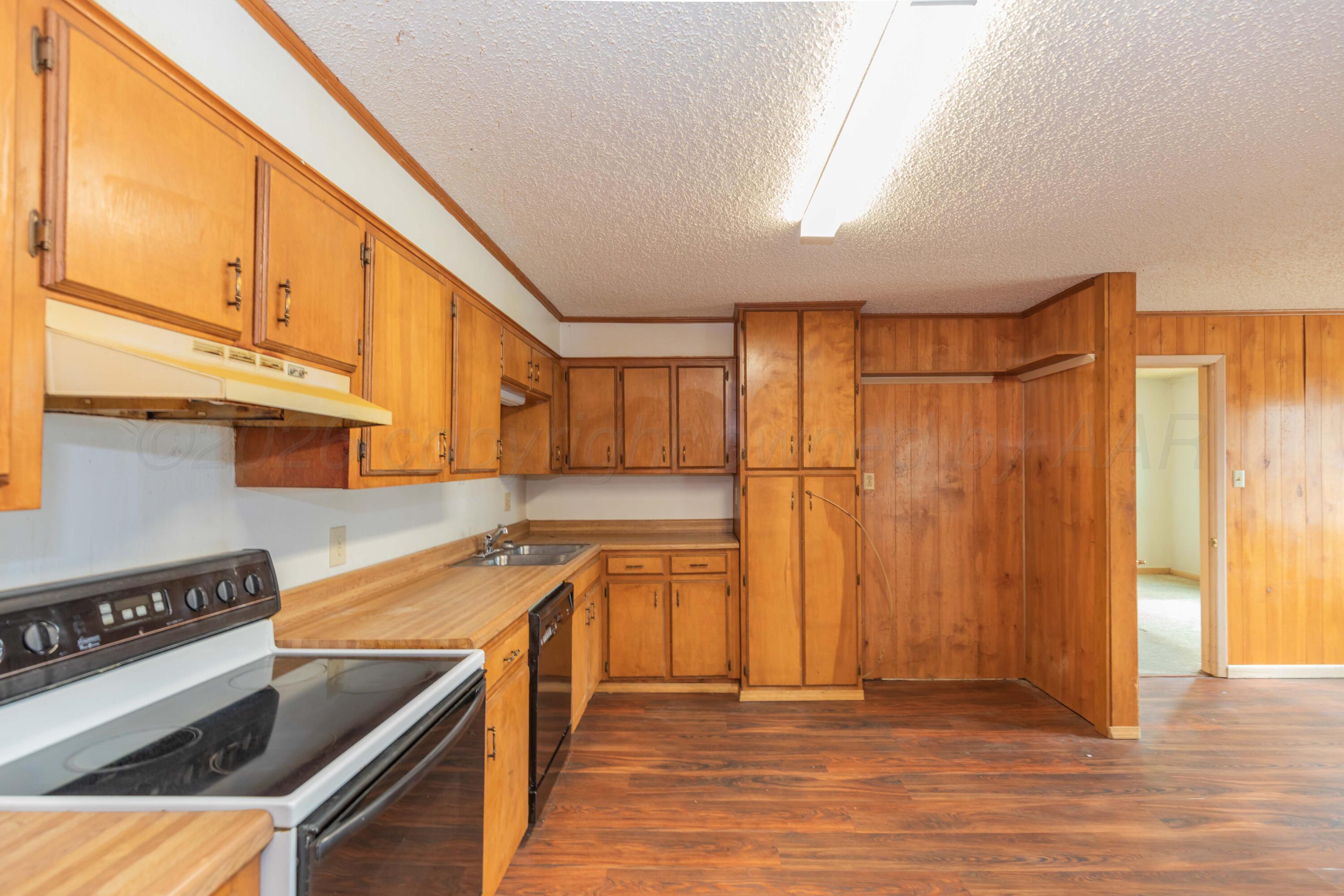 200 South Wall Street Shamrock, TX 79079 - Photo 9 of 40 a kitchen with stainless steel appliances granite countertop a sink a stove and a refrigerator
