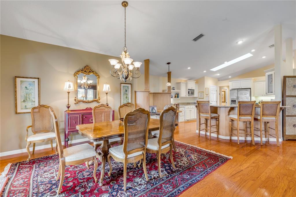 1098 Red Maple Way New Smyrna Beach, FL 32168 - Photo 13 of 78 a view of a dining room and livingroom with furniture wooden floor a rug a chandelier and a mirror