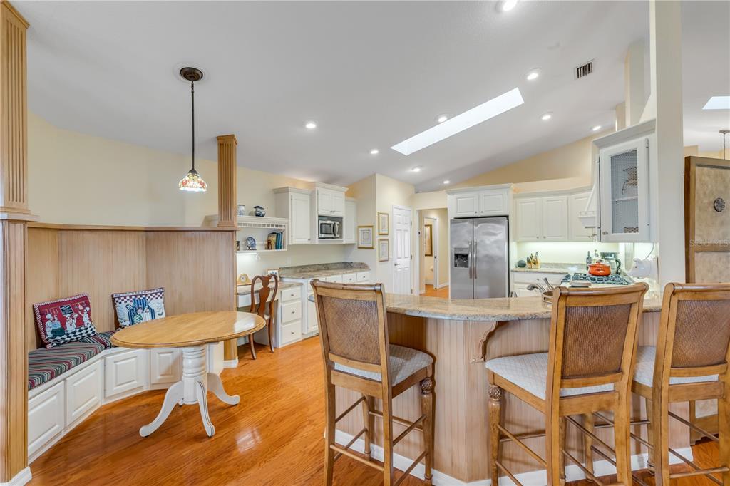 1098 Red Maple Way New Smyrna Beach, FL 32168 - Photo 17 of 78 a kitchen with stainless steel appliances kitchen island granite countertop a dining table chairs and white cabinets