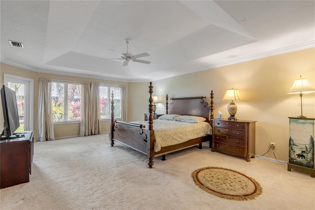 1098 Red Maple Way New Smyrna Beach, FL 32168 - Photo 28 of 78 a bedroom with a bed a mirror and a flat screen television