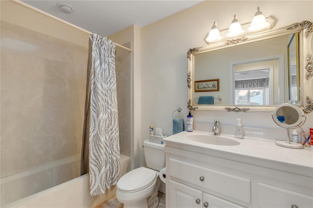 1098 Red Maple Way New Smyrna Beach, FL 32168 - Photo 41 of 78 a bathroom with a sink a toilet a mirror a bathtub and shower
