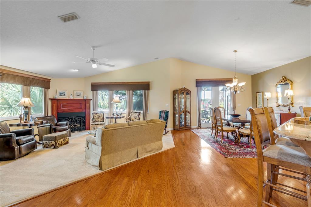 1098 Red Maple Way New Smyrna Beach, FL 32168 - Photo 7 of 78 a living room with furniture a dining table and chairs with wooden floor