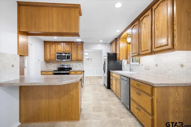 a kitchen with stainless steel appliances granite countertop a sink a stove and a refrigerator