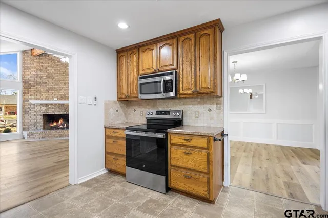 a kitchen with stainless steel appliances granite countertop a stove a sink and a microwave