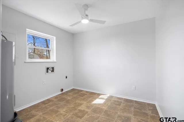 a view of a big room with windows and chandelier fan