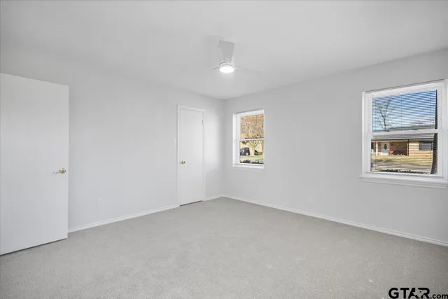 a bathroom with a granite countertop sink a toilet and a mirror