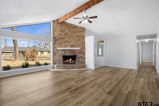 a view of empty room with wooden floor and fireplace
