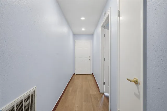 a view of a hallway with wooden floor and staircase
