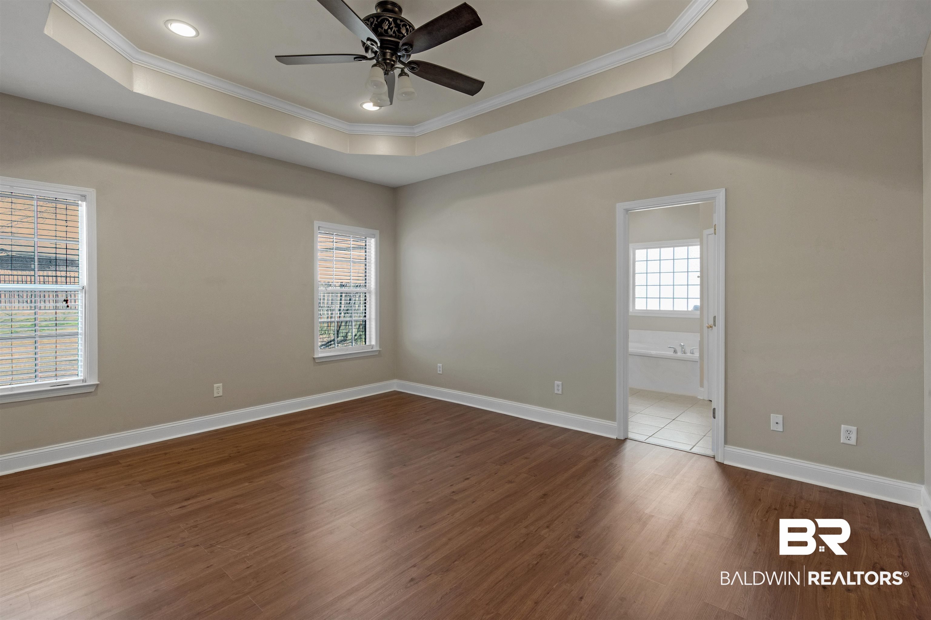 330 Allison Court Mobile, AL 36608 - Photo 12 of 27 Unfurnished room featuring dark wood-type flooring, ceiling fan, crown molding, and a raised ceiling
