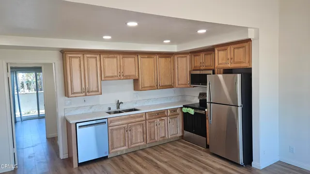 a kitchen with a refrigerator a sink and cabinets