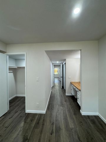 a room with a wooden floor and a bathroom view