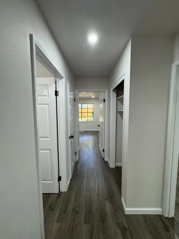 a view of a hallway with wooden floor
