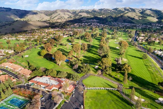a large white kitchen with wooden floors and view living room