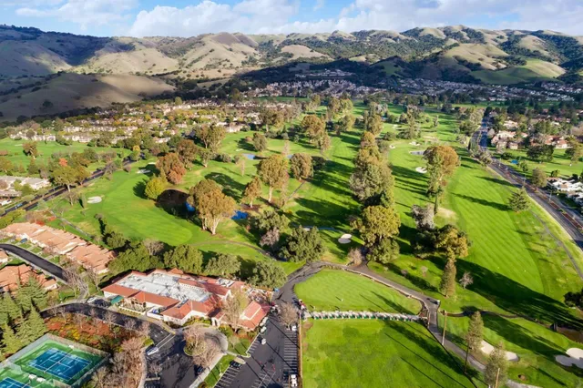 a large white kitchen with wooden floors and view living room