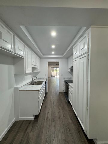 a kitchen with granite countertop white cabinets and white appliances