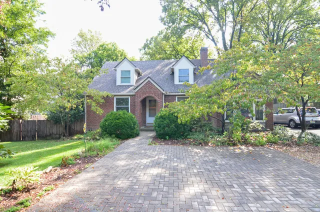 a front view of a house with a yard and shrubs