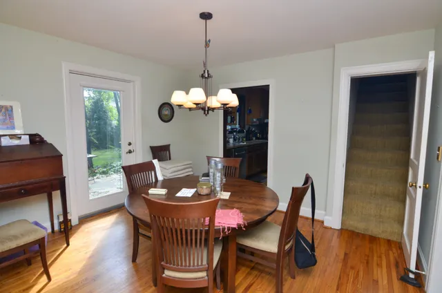 a dining room with furniture a chandelier and wooden floor