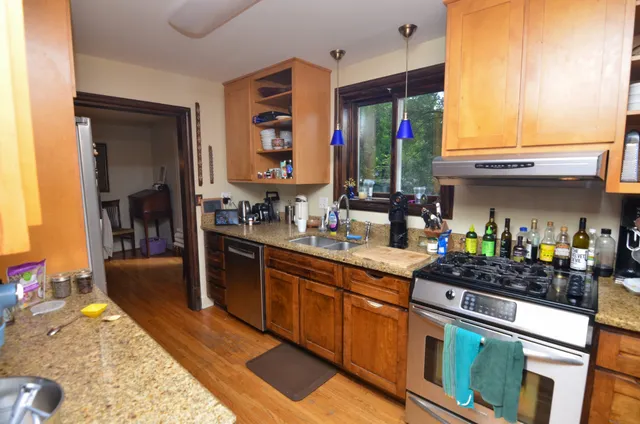 a kitchen with stainless steel appliances granite countertop a stove a sink and a refrigerator