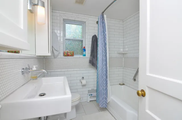 a bathroom with a tub a sink and a window