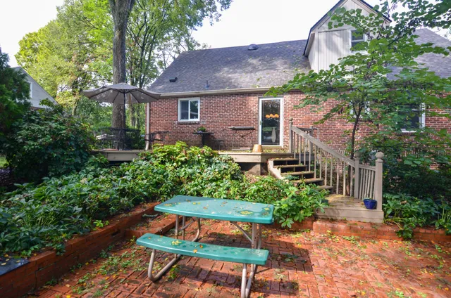 a backyard of a house with table and chairs and potted plants