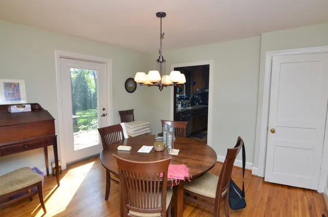 a dining room with furniture a chandelier and wooden floor