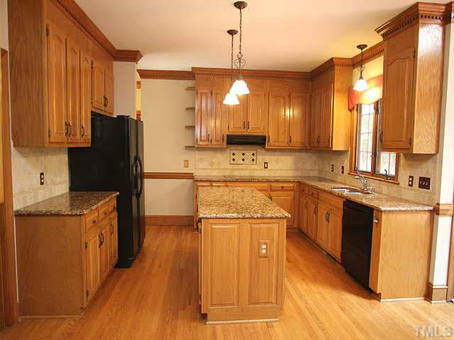 6116 Battleview Drive Raleigh, NC 27613 - Photo 3 of 13 a kitchen with stainless steel appliances granite countertop a refrigerator a sink dishwasher and wooden cabinets with wooden floor
