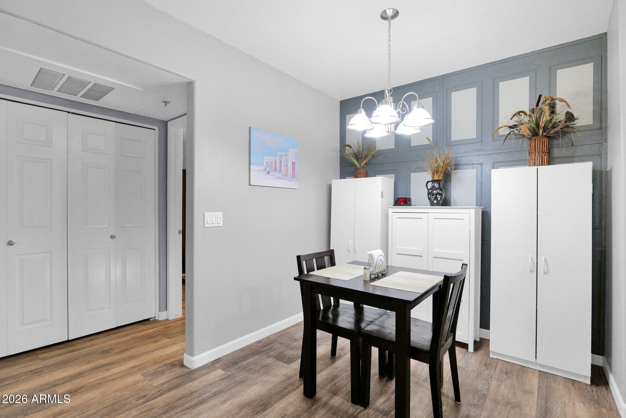 1295 North Ash Street, Unit 624 Gilbert, AZ 85233 - Photo 7 of 39 a dining room with furniture wooden floor a chandelier