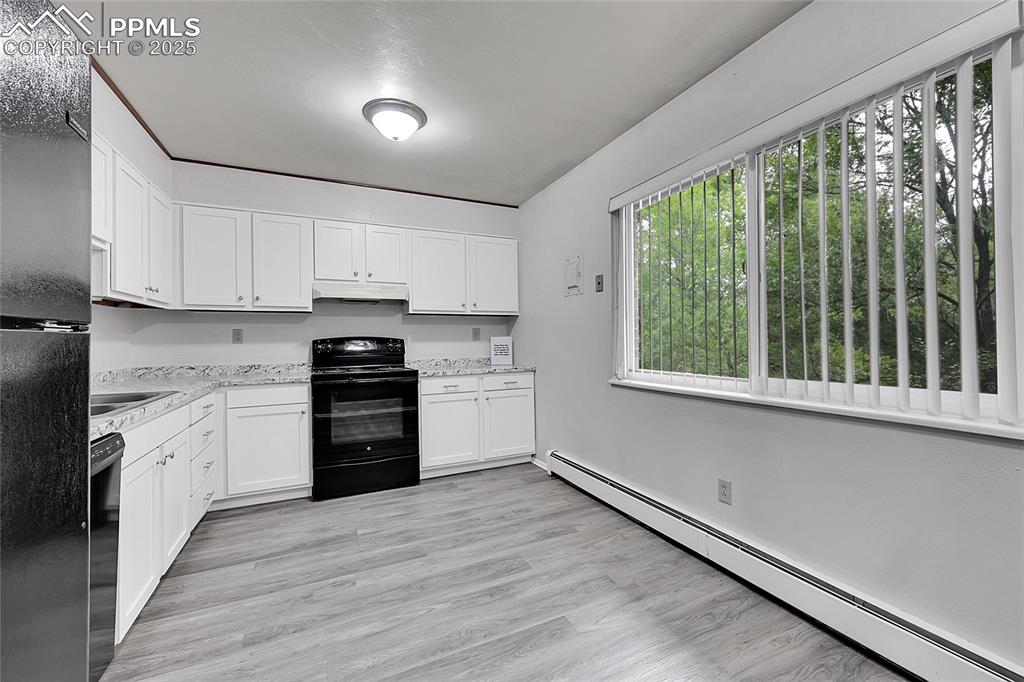6633 Dublin Loop West, Unit 4 Colorado Springs, CO 80918 - Photo 25 of 33 a kitchen with a white cabinets and wooden floor