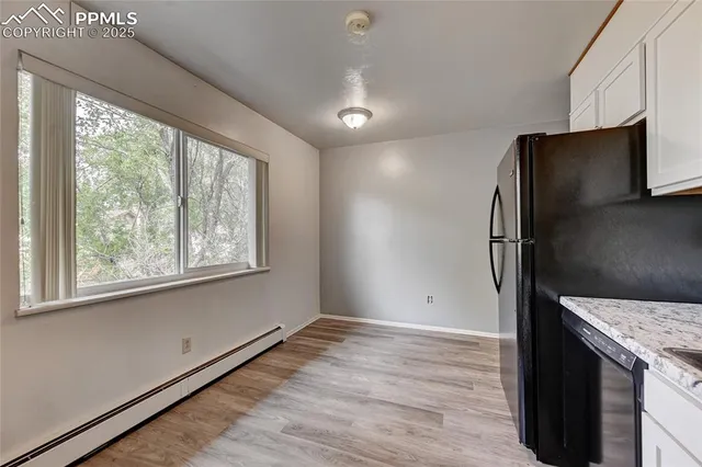 an empty room with wooden floor and a window