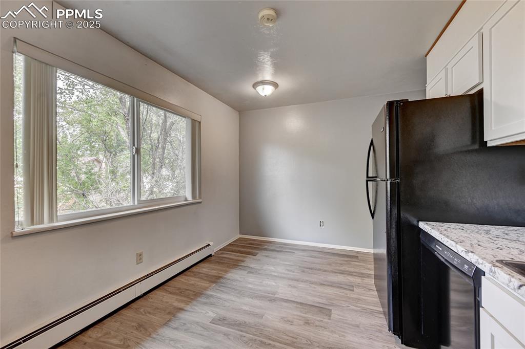 6633 Dublin Loop West, Unit 4 Colorado Springs, CO 80918 - Photo 9 of 33 an empty room with wooden floor and a window