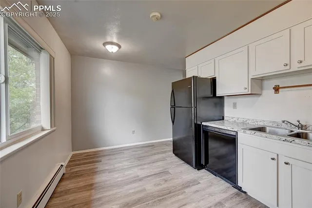 a kitchen with a refrigerator sink and cabinets