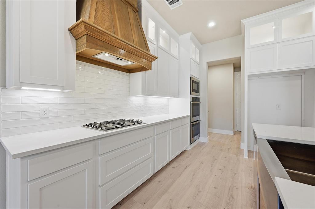 1053 Llano Way Poolville, TX 76487 - Photo 17 of 40 a kitchen with stainless steel appliances granite countertop a stove a sink and a refrigerator