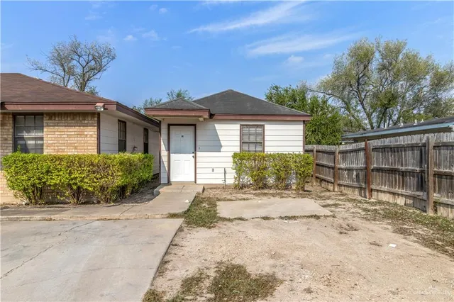a front view of a house with a yard and potted plants