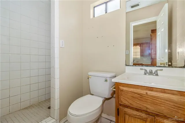 a bathroom with a granite countertop toilet a sink and a mirror