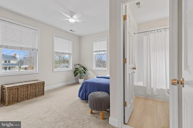a bathroom with a granite countertop sink vanity mirror and toilet