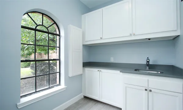 a kitchen with granite countertop white cabinets and a window