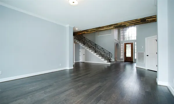 a view of a hallway with wooden floor and stairs