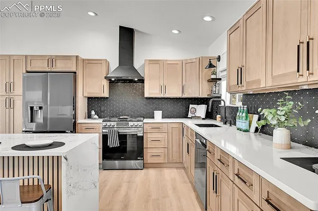 a kitchen with stainless steel appliances granite countertop a stove a sink dishwasher and a refrigerator